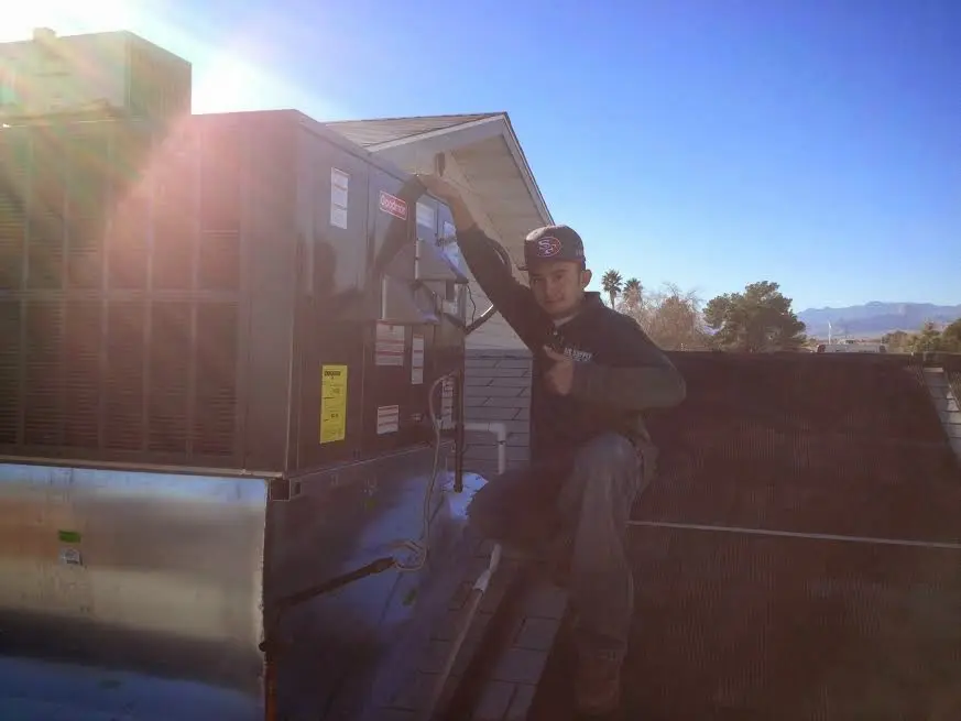 HVAC technician performing Heat Pump Repair on a rooftop unit in Riverton